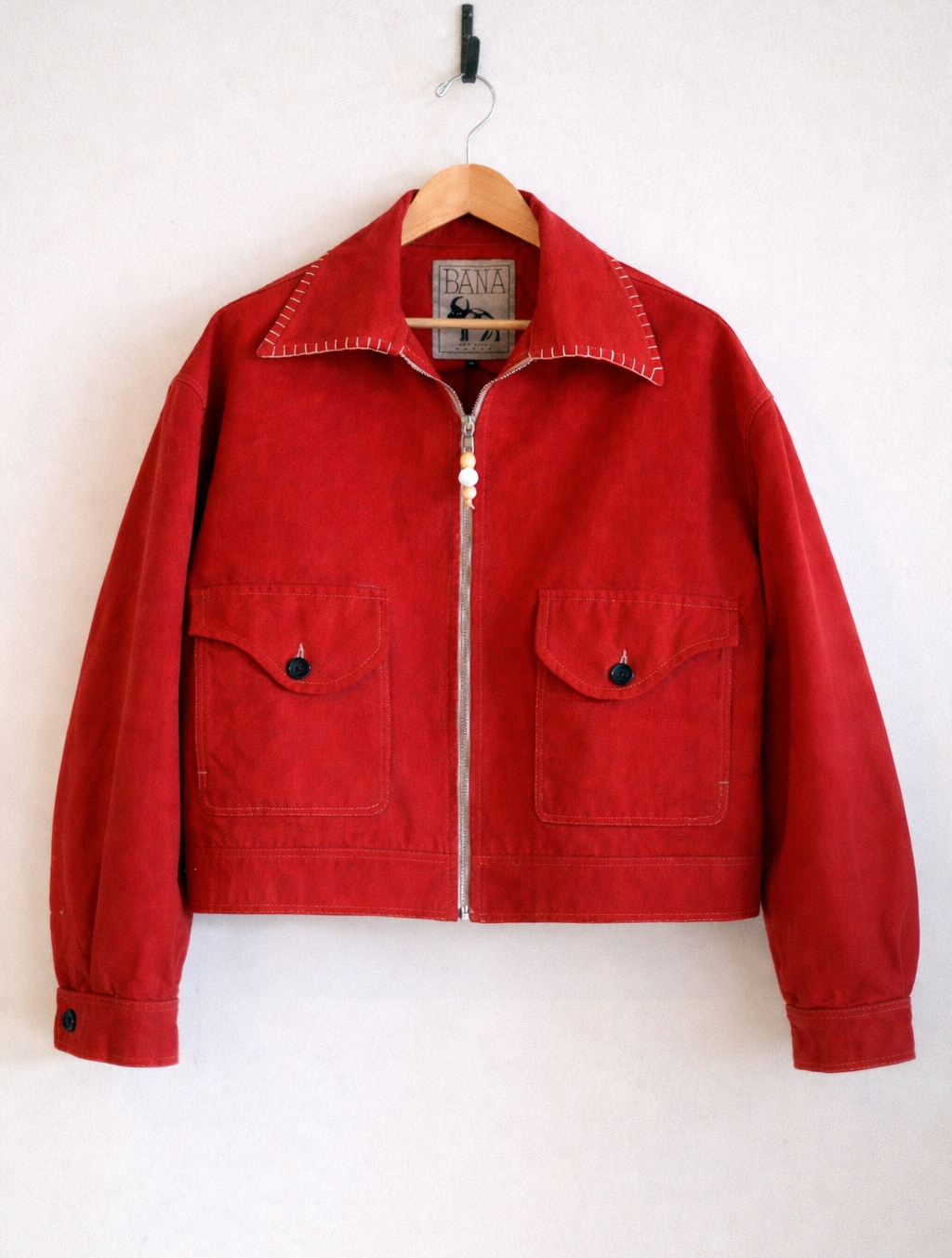 Red jacket on a hanger against a white background